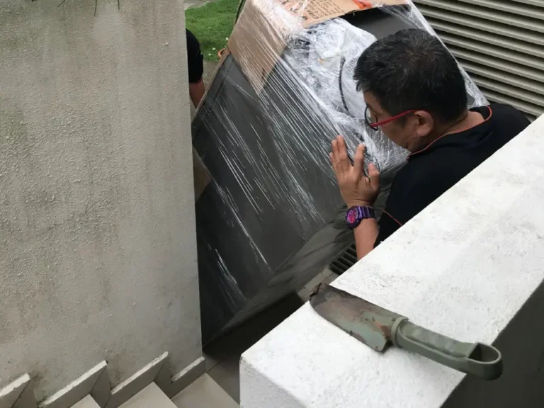 Experienced Elite Movers team moving a refrigerator through a narrow stairway