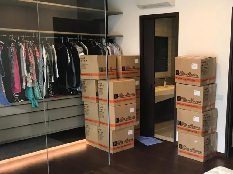 Elite Movers moving boxes into customer's bedroom