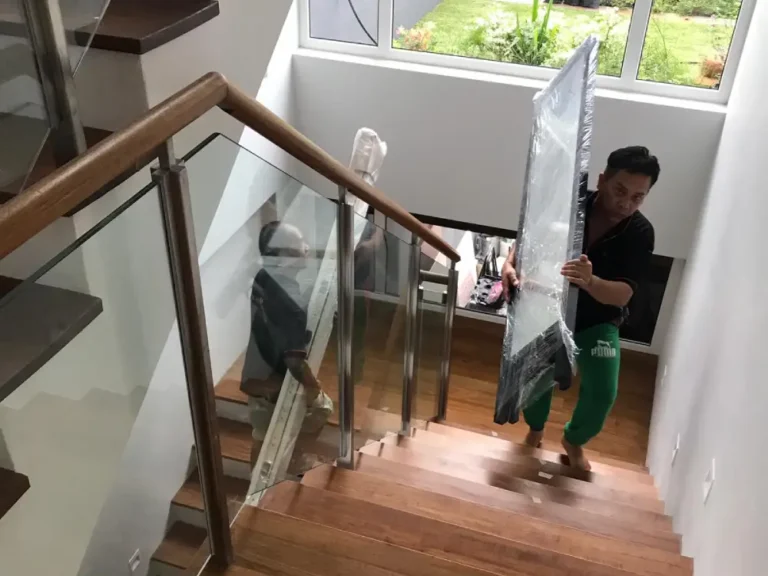 Elite Movers team moving mirror and frame up a flight of stairs